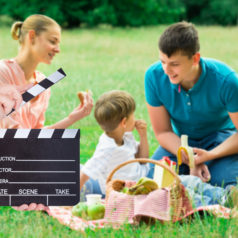 Young Happy Family Enjoying Breakfast At Picnic In The Park